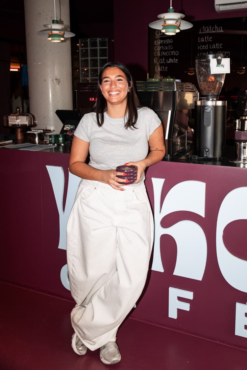 YOKO barista smiling behind the counter with a ceramic cup